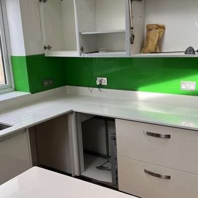 bianco carrara quartz worktop with green glass splashback